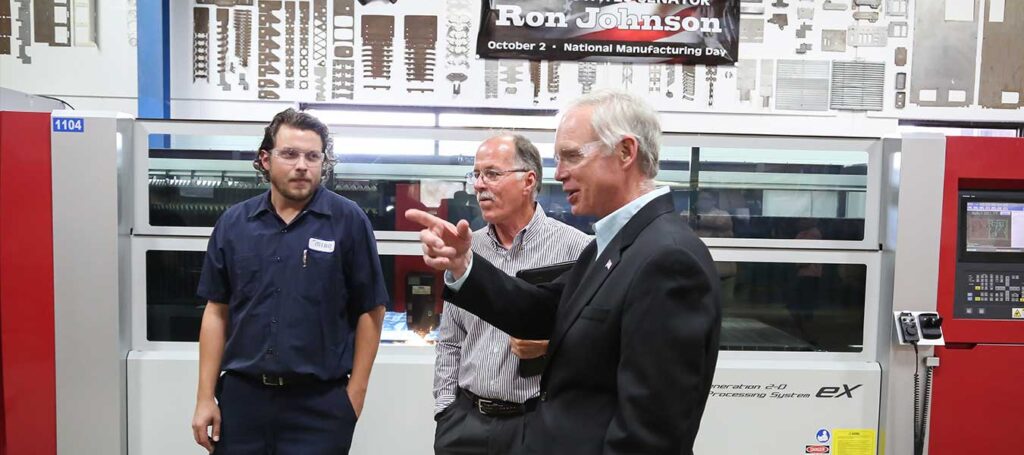 United States Senator Ron Johnson visiting Miro Manufacturing, discussing the Mitsubishi eX Series laser with Miro President Jeff Brown and an employee during National Manufacturing Day.