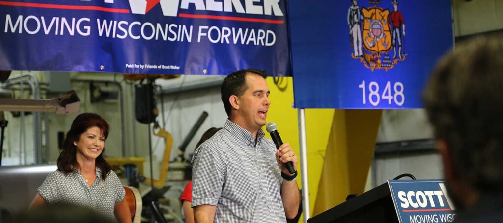 Wisconsin Governor Scott Walker delivers a talk at Miro Manufacturing with Lieutenant Governor Rebecca Kleefisch listening on in the background.